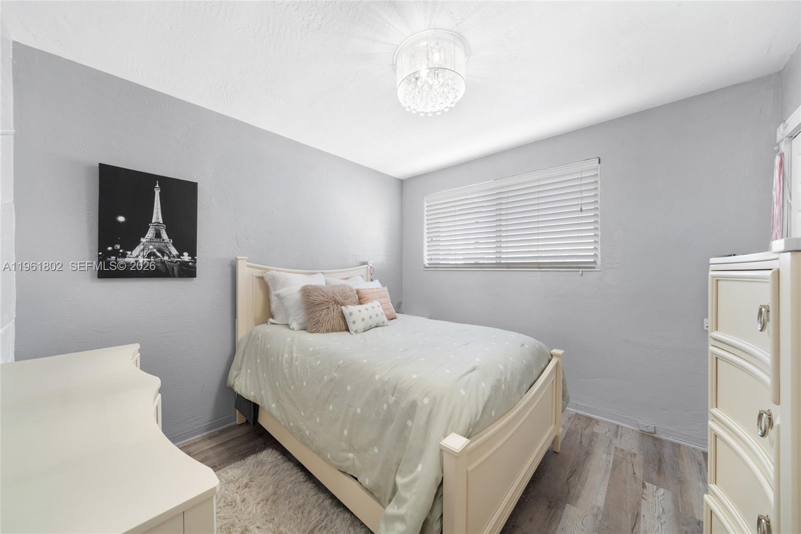 1166 West 24th Street Hialeah, FL 33010 - Photo 12 of 45 a bedroom with a bed and a chandelier