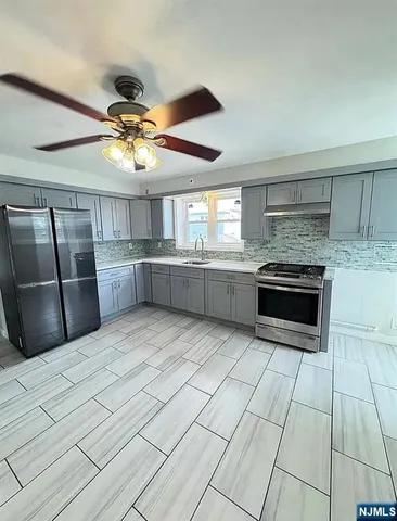 a kitchen with stainless steel appliances granite countertop a stove and a refrigerator