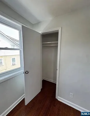 an empty room with wooden floor and a window