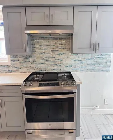 a stove top oven sitting inside of a kitchen