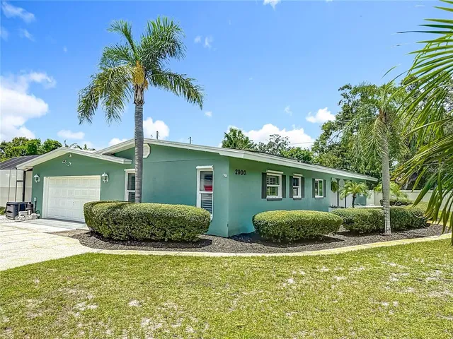 a front view of house with yard and trees around