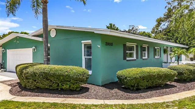 a kitchen with granite countertop white cabinets white appliances a sink and dishwasher with wooden floor