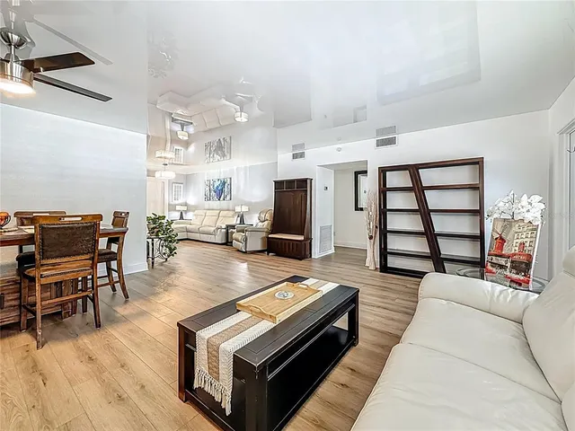 a living room with furniture a large window and a wooden floor