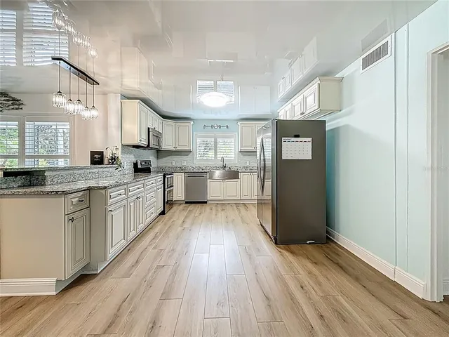 a bathroom with a granite countertop sink a mirror and shower