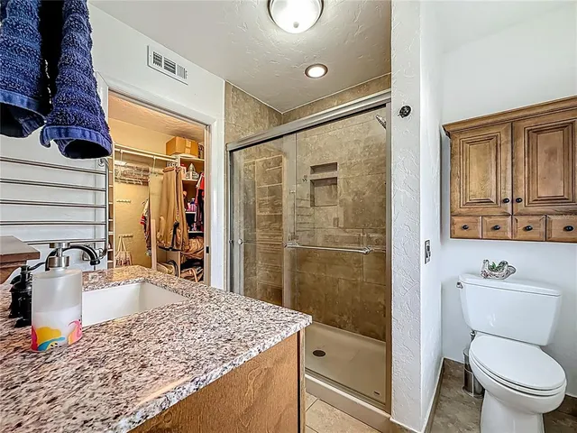 a view of a tennis ground with large trees in front of it