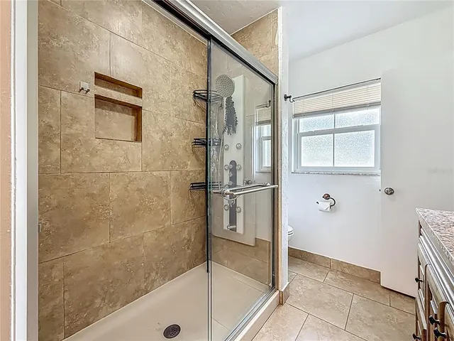 a living room with patio furniture and a floor to ceiling window