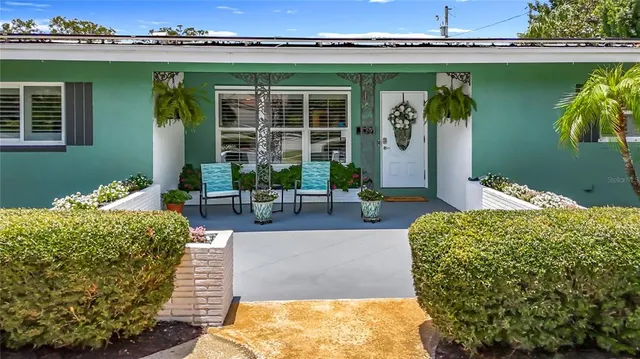 a view of a patio with table and chairs and potted plants