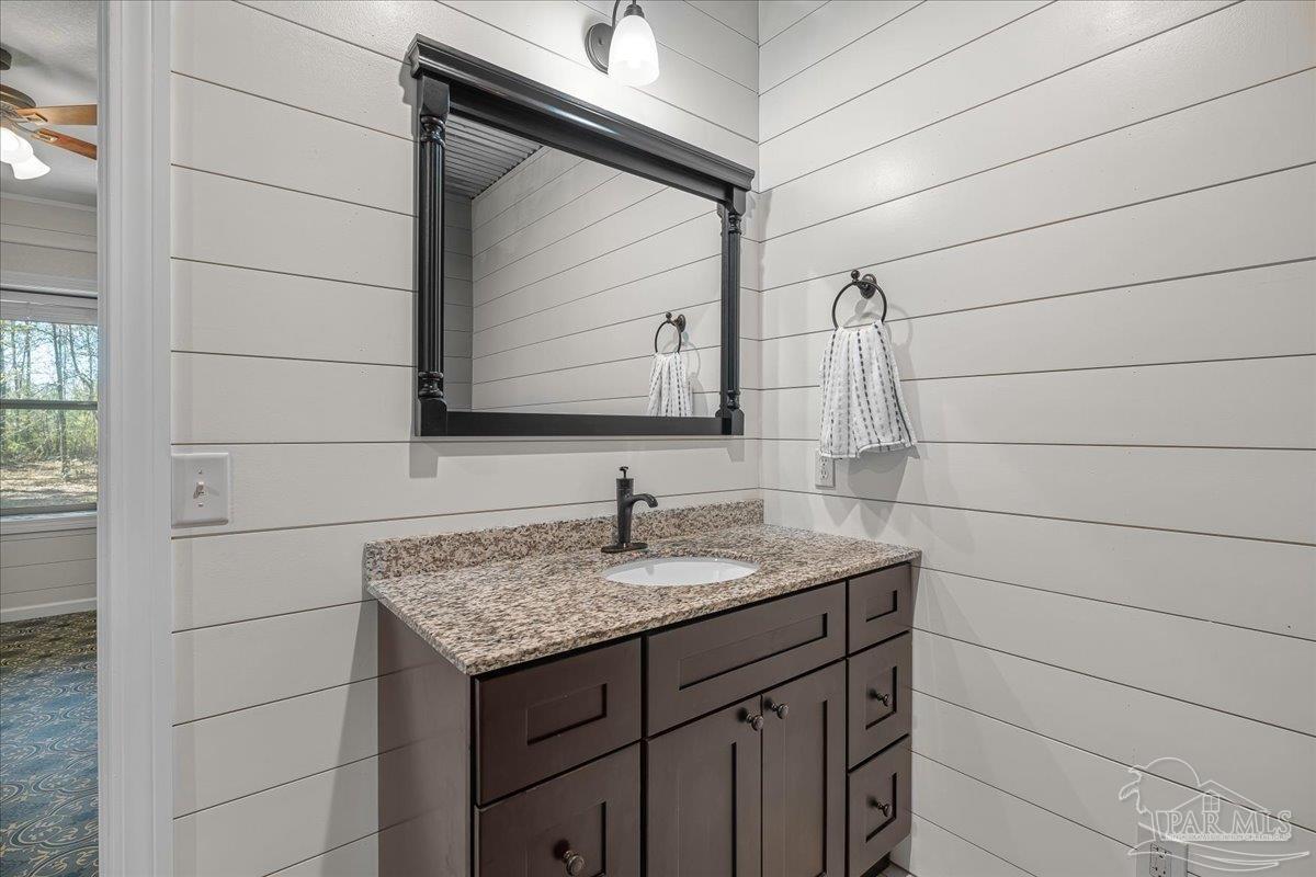 1660 Annie Penton Road Jay, FL 32565 - Photo 32 of 56 a bathroom with a granite countertop sink and a mirror