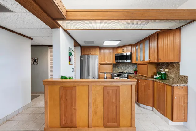 a kitchen with stainless steel appliances granite countertop a refrigerator and a stove top oven