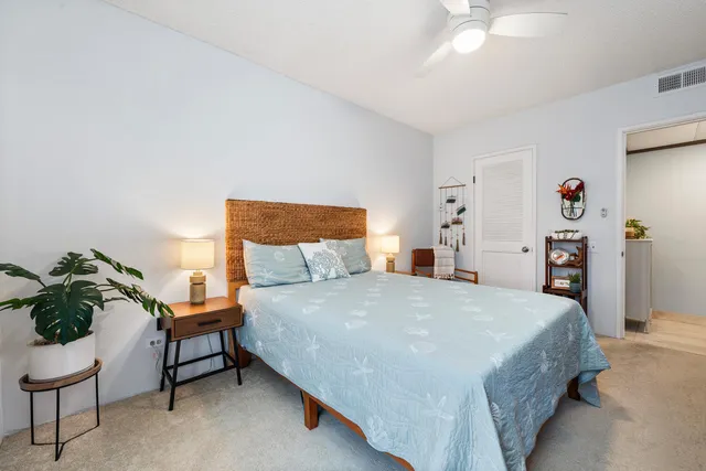 a bedroom with a bed and a potted plant