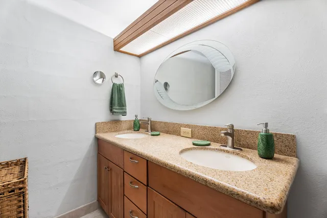 a bathroom with a granite countertop sink and a mirror