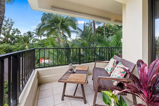 a view of a balcony with chairs and a potted plant