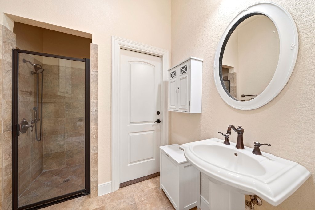 143 Champion Way Spring Branch, TX 78070 - Photo 20 of 40 a bathroom with a sink a mirror a vanity and a shower