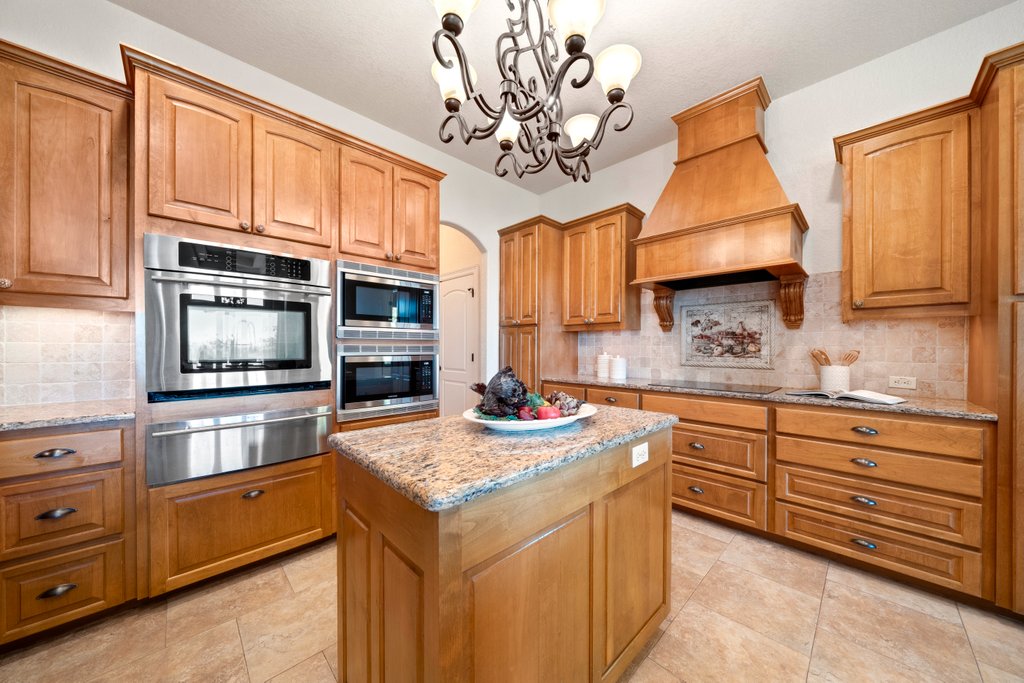 143 Champion Way Spring Branch, TX 78070 - Photo 7 of 40 a kitchen with stainless steel appliances granite countertop a stove and cabinets