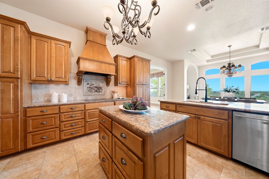 143 Champion Way Spring Branch, TX 78070 - Photo 8 of 40 a kitchen with a sink a stove a refrigerator and cabinets