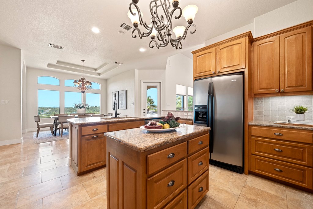 143 Champion Way Spring Branch, TX 78070 - Photo 9 of 40 a kitchen with stainless steel appliances granite countertop a sink stove and refrigerator