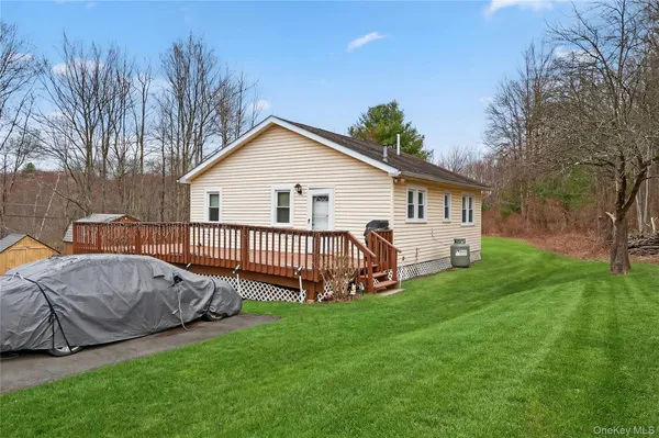 a view of a house with a yard and deck