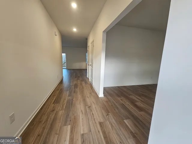 a view of a hallway with wooden floor