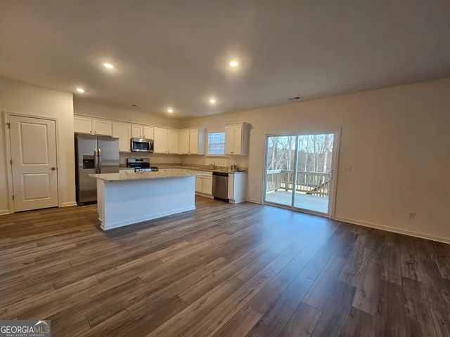 a large kitchen with wooden floors and stainless steel appliances