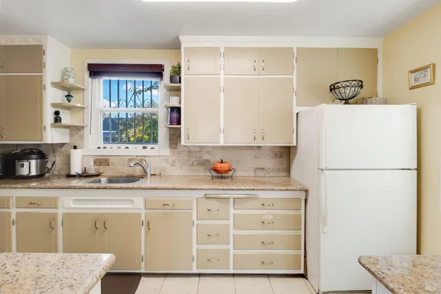 a kitchen with granite countertop cabinets and a refrigerator