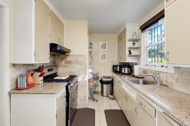 a kitchen with a sink stove top oven and cabinets