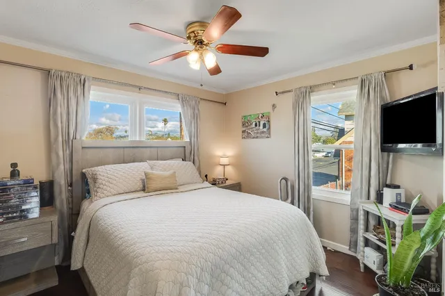a bedroom with a bed and a flat tv screen on the dresser