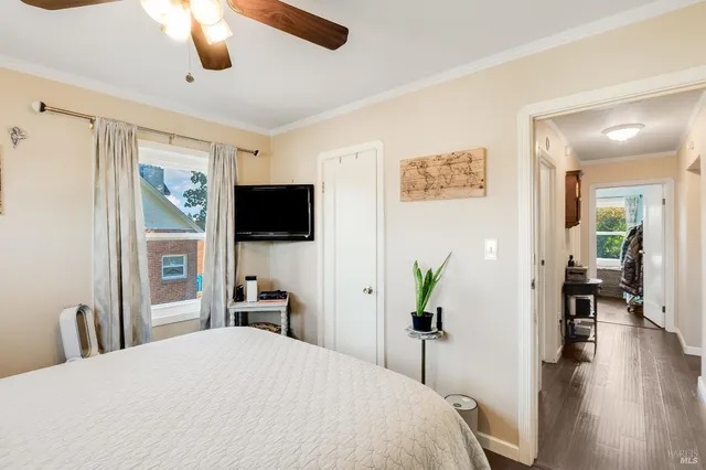 a bedroom with a bed and a flat tv screen on dresser