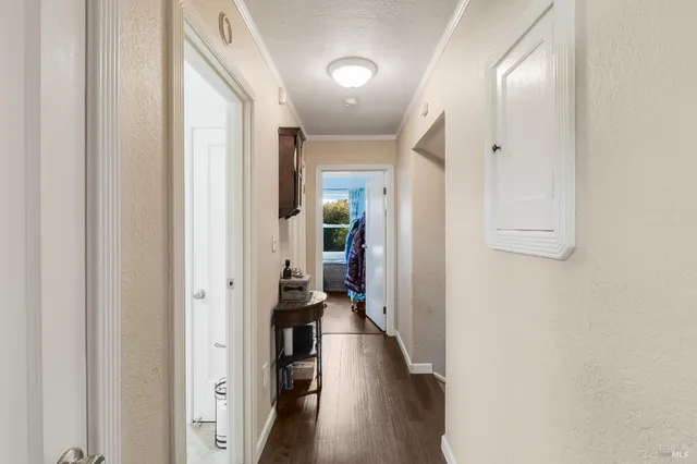 a view of hallway with livingroom and wooden floor