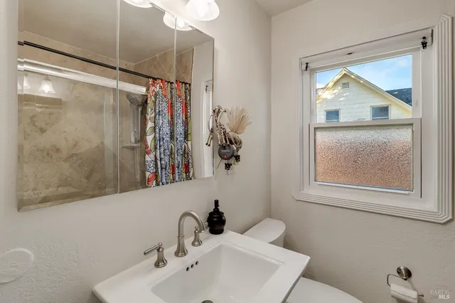 a bathroom with a toilet a sink and a window