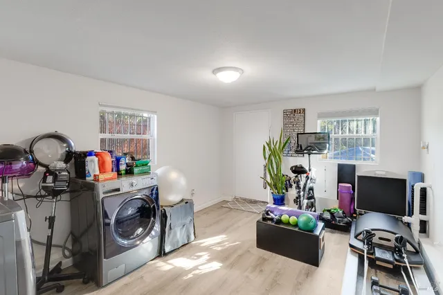 a utility room with cabinets a sink and a painting on the wall