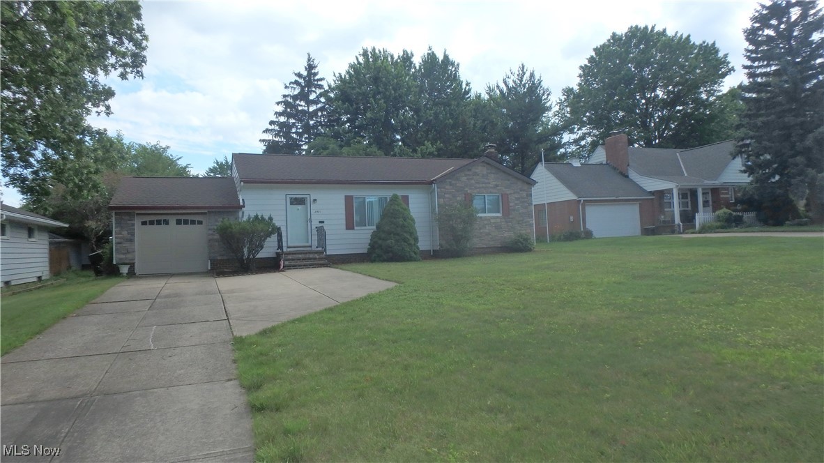 Ranch-style home with entry steps, concrete driveway, a front lawn, and stone siding