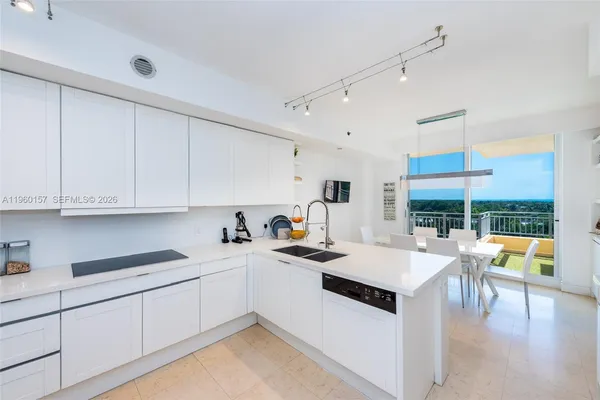 a kitchen with a stove a refrigerator and white cabinets