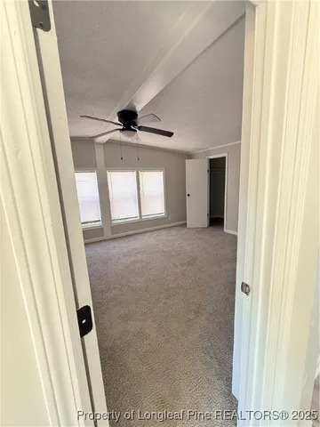 en empty room with windows and ceiling fan