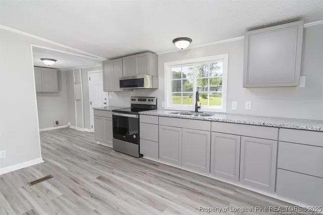 a kitchen with stainless steel appliances granite countertop a sink stove and refrigerator