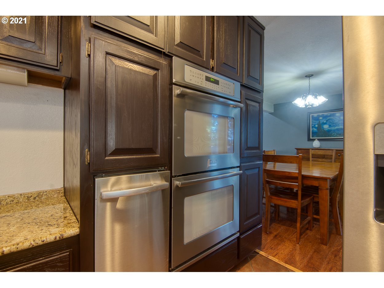 1845 Oak Street North Bend, OR 97459 - Photo 10 of 31 a kitchen with kitchen island granite countertop a refrigerator and a sink