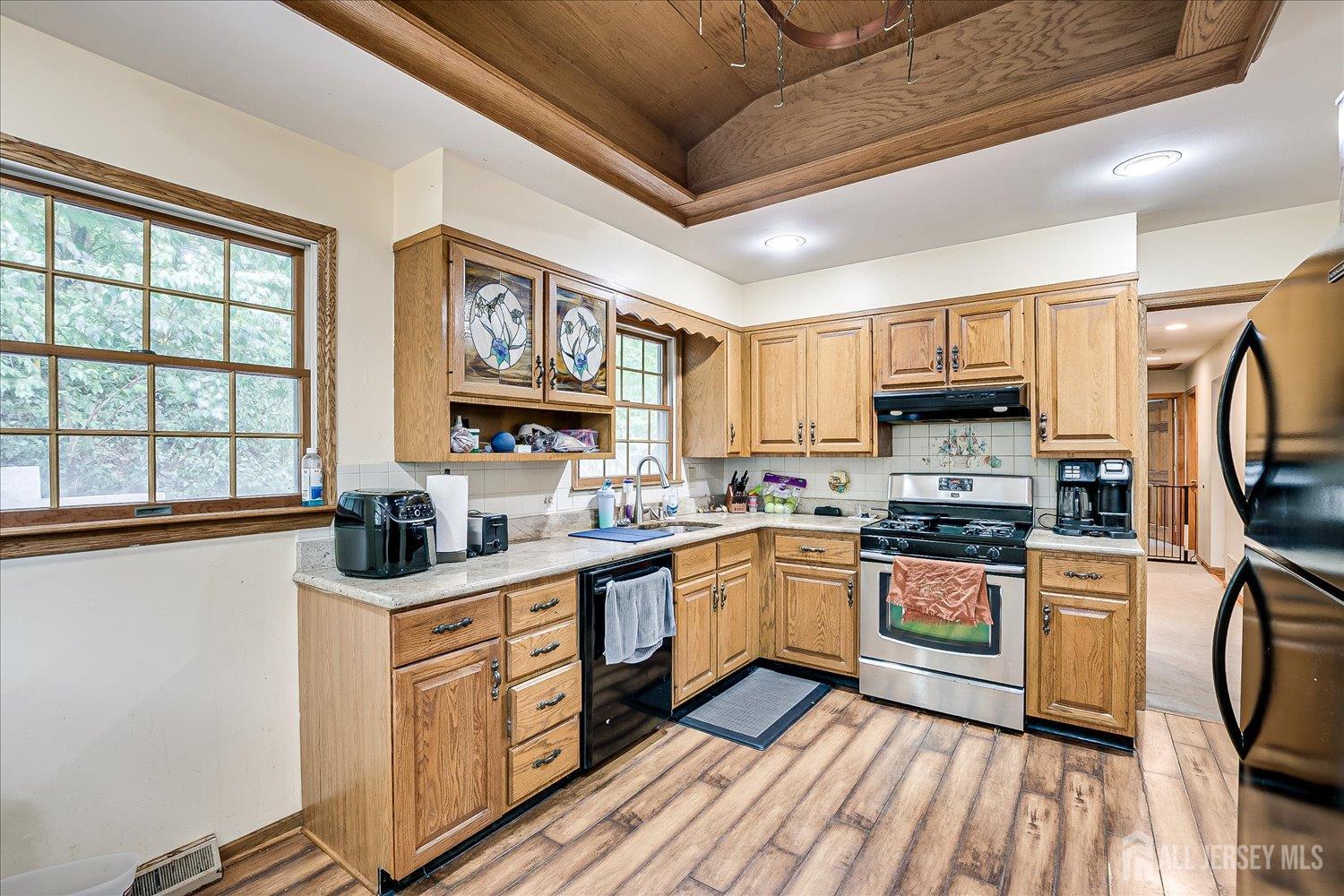 23 Cardownie Street Edison, NJ 08817 - Photo 44 of 65 a kitchen with stainless steel appliances granite countertop a stove top oven a sink dishwasher and white cabinets with wooden floor