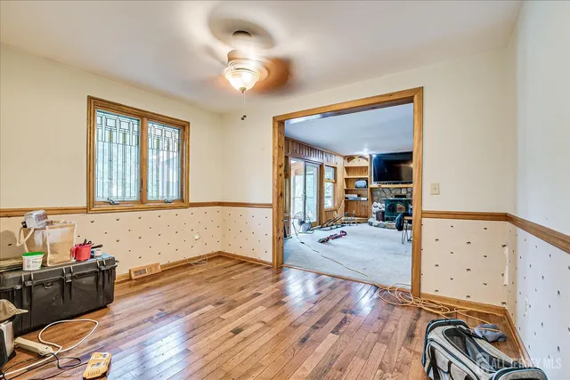 a view of an empty room with wooden floor and closet