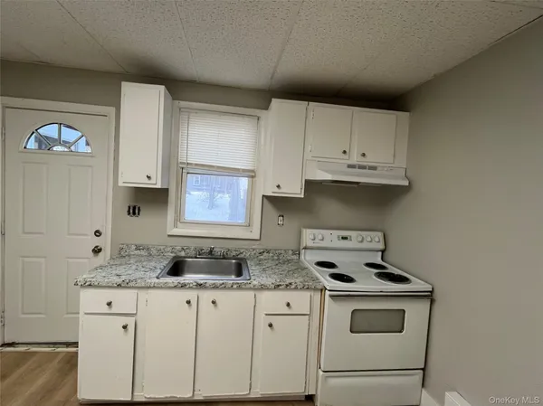 a kitchen with granite countertop white cabinets and a stove