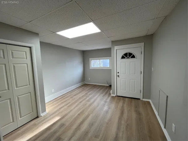a view of empty room with wooden floor and window