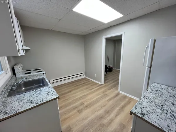 a kitchen with granite countertop a stove and a refrigerator