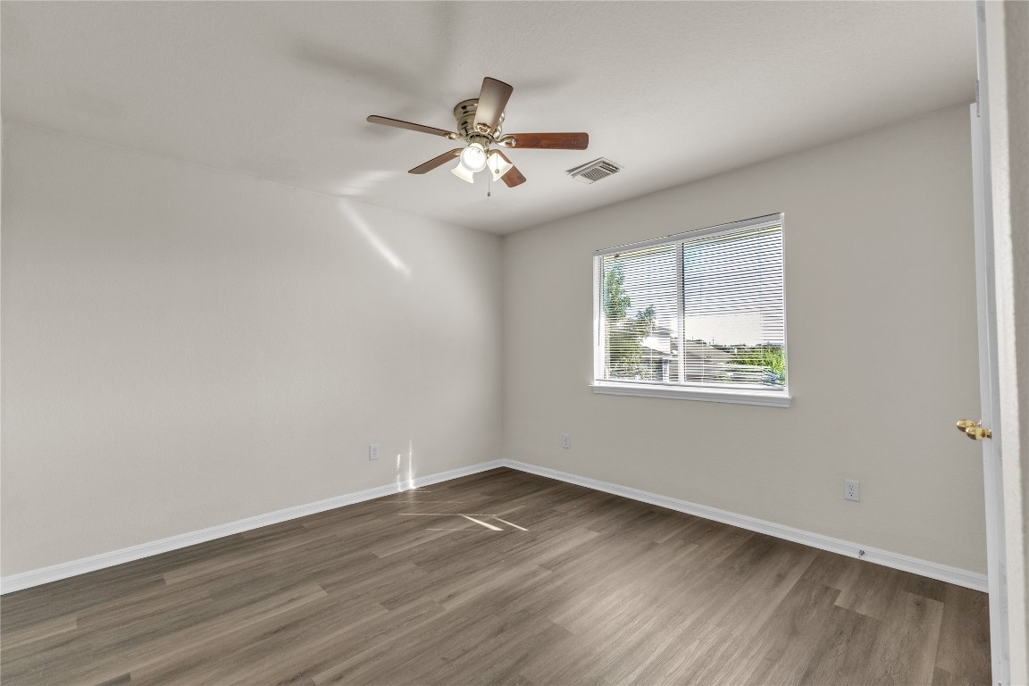 3733 Eagles Nest Street Round Rock, TX 78665 - Photo 13 of 19 an empty room with wooden floor chandelier fan and windows
