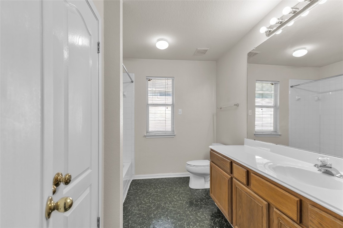 3733 Eagles Nest Street Round Rock, TX 78665 - Photo 15 of 19 a spacious bathroom with a toilet a sink and mirror