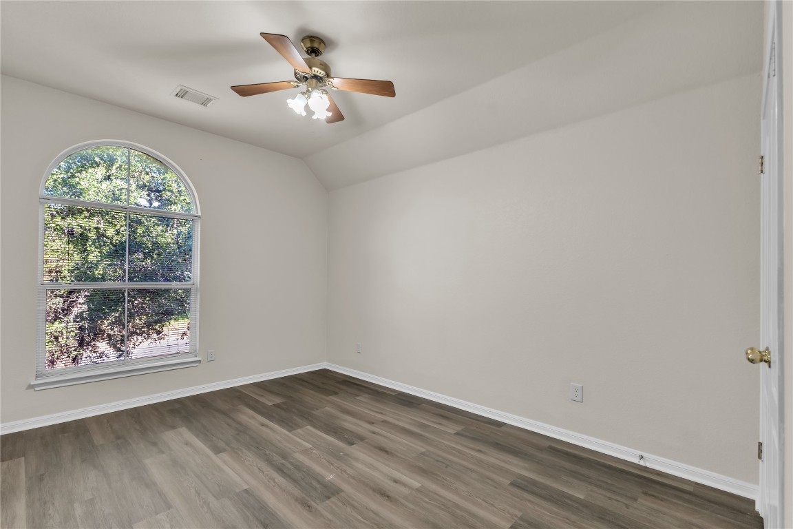 3733 Eagles Nest Street Round Rock, TX 78665 - Photo 16 of 19 an empty room with wooden floor chandelier fan and windows