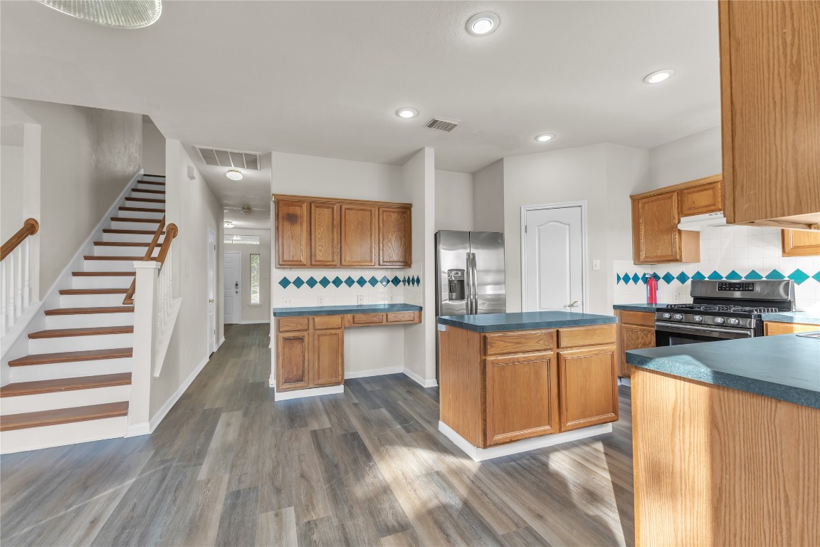 3733 Eagles Nest Street Round Rock, TX 78665 - Photo 6 of 19 a kitchen with stainless steel appliances granite countertop a refrigerator a stove top oven and wooden floors
