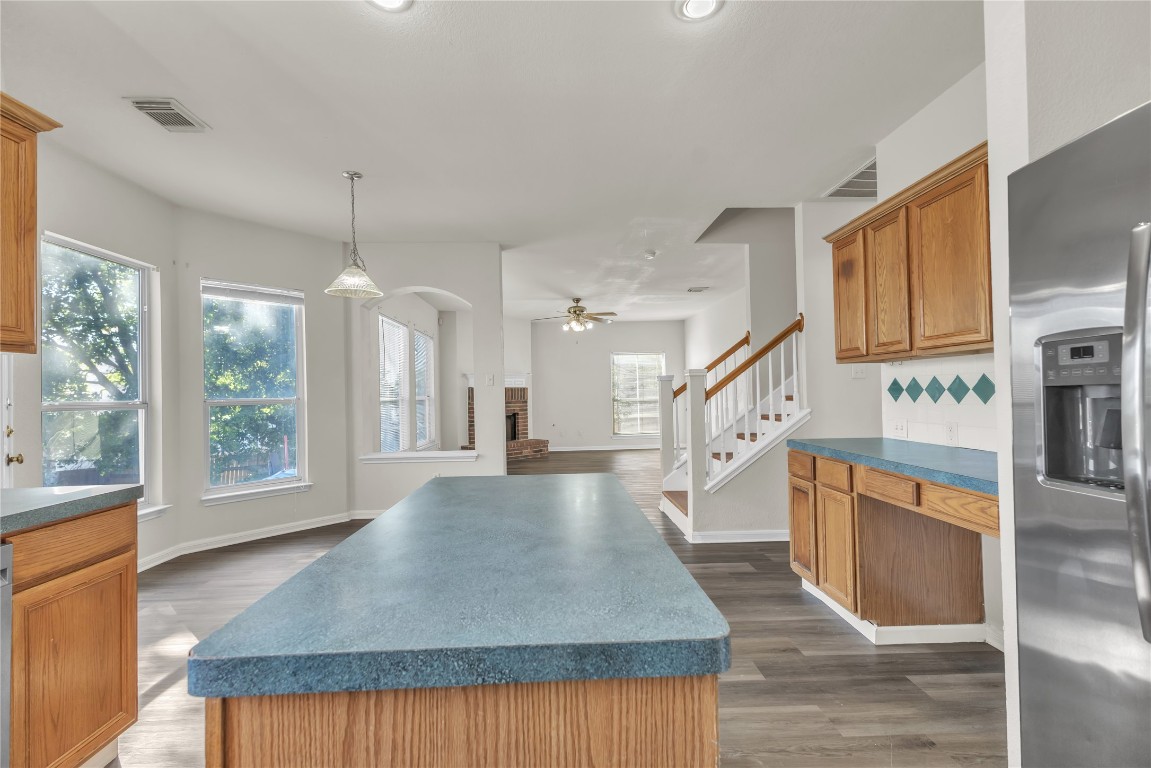 3733 Eagles Nest Street Round Rock, TX 78665 - Photo 7 of 19 a open kitchen with stainless steel appliances granite countertop a stove top oven a sink dishwasher and a refrigerator with wooden floor