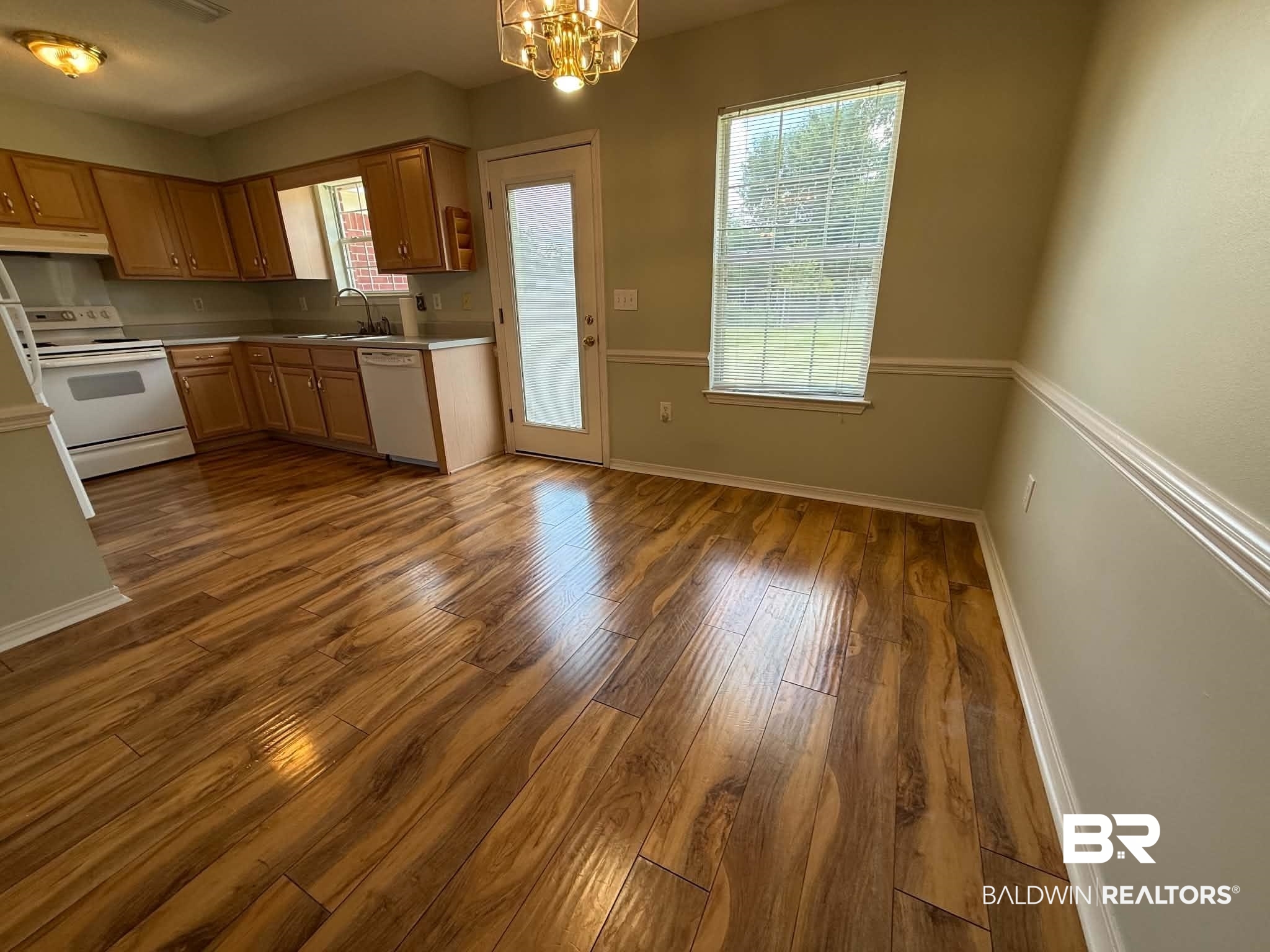 123 Pennbrooke Loop Foley, AL 36535 - Photo 23 of 49 Open-concept kitchen and dining area featuring wood-finish flooring, light wood cabinetry, a built-in dishwasher, white appliances, and a glass-paneled exterior door