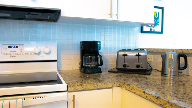 a kitchen with stainless steel appliances granite countertop a refrigerator a stove and a cabinets with wooden floor