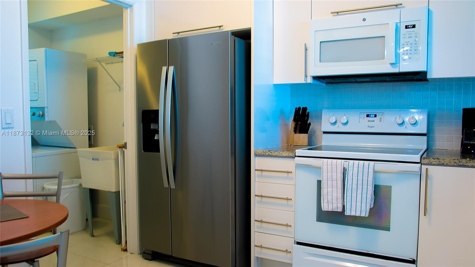 18100 North Bay Road, Unit 905 Sunny Isles Beach, FL 33160 - Photo 16 of 25 a kitchen with stainless steel appliances granite countertop a refrigerator a stove and a cabinets with wooden floor