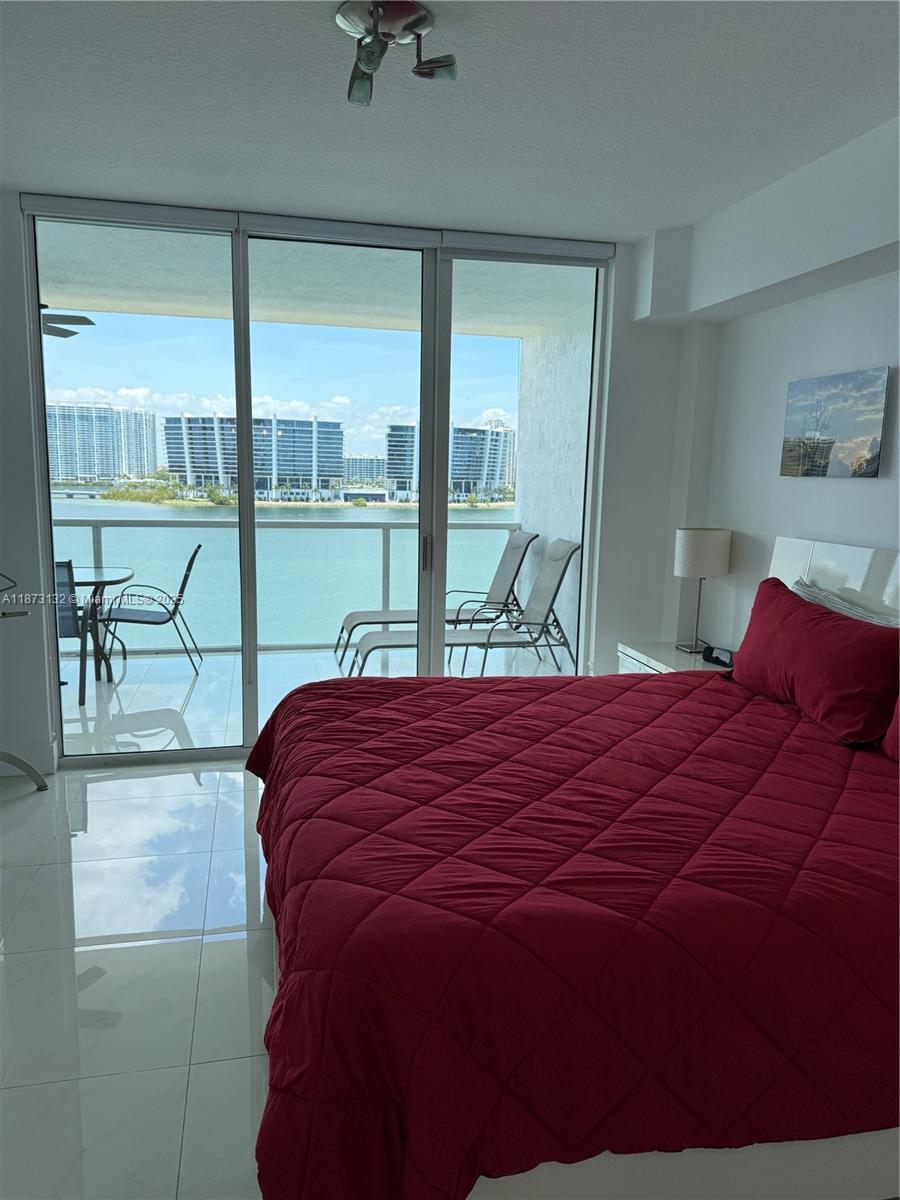 18100 North Bay Road, Unit 905 Sunny Isles Beach, FL 33160 - Photo 22 of 25 a bed sitting in a bedroom next to a window