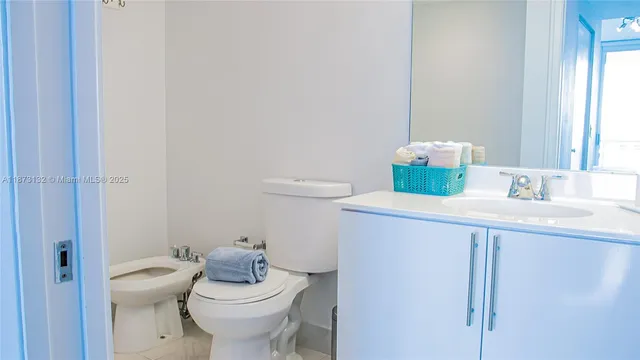 a bathroom with a granite countertop sink and a toilet